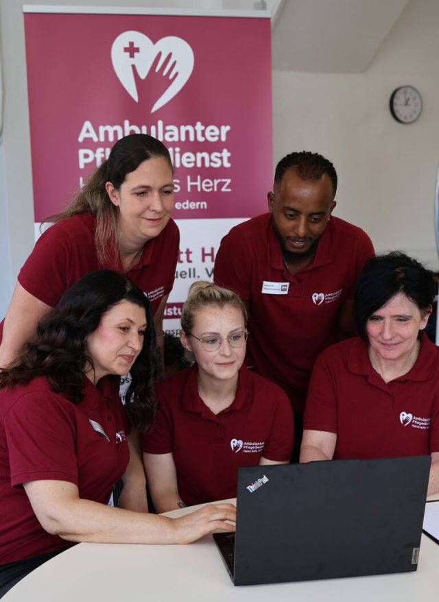 pflege team hand aufs herz meeting laptop e1754074079670